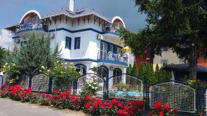 a white house with red flowers in front of it at Judit haus in Balatonfüred