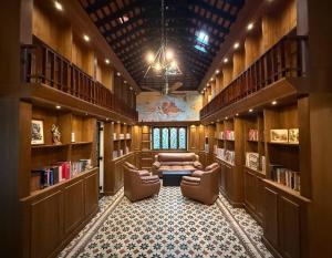 a library with two chairs and a couch in the middle at Malkin Hostel in Arpora