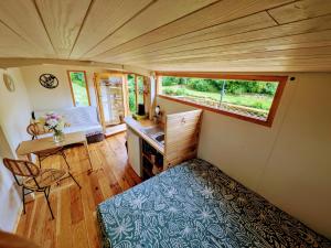 a small room with a bed and a desk in a tiny house at Au silence des Peupliers in Litteau