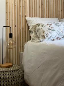 a bed with a pillow and a lamp on a table at Coeur de ville rue de la Paix in Laval