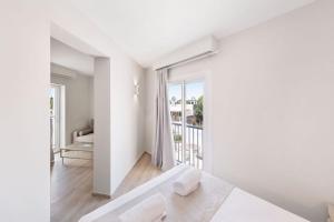 a white room with a bed and a balcony at Hotel Ankaa - Adults Only in Porto Cristo
