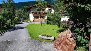 a house on a road with a large rock at FEWO Wimmer in Bischofswiesen
