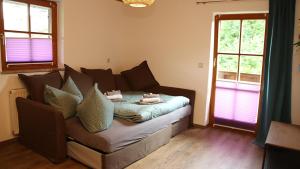 a living room with a couch and two windows at FEWO Wimmer in Bischofswiesen