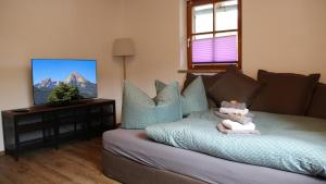 a living room with a bed with towels on it at FEWO Wimmer in Bischofswiesen
