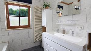 a white bathroom with a sink and a window at FEWO Wimmer in Bischofswiesen +12 photos