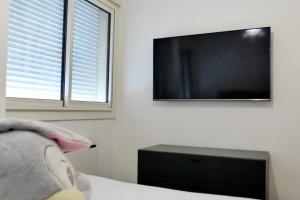 une chambre avec une télévision à écran plat au mur dans l'établissement Apartment with garden 200 m from the beach, à Sanary-sur-Mer 11 autres photos
