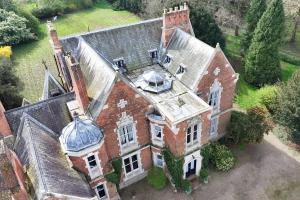 an aerial view of a large brick house with a roof at The Meadow Suite, Enholmes Hall in Patrington +9 photos