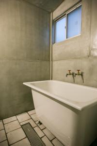 a white bath tub in a bathroom with a window at 青鵺 Aoya Private entire House near the Nijo castle in Kyoto +23 photos