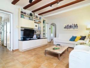Una sala de estar con un sofá blanco y un televisor. en Encantadora villa en Javea con piscina privada y aire acondicionado, cerca de la playa - ES-160-18, en Denia