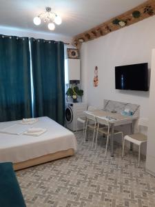 a room with two beds and a table and a tv at Seatime Studio in primul rând la mare in Mamaia Sat/Năvodari