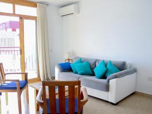 a living room with a couch with blue pillows at Apartamento encantador con piscina y aire acondicionado cerca de la playa de Jávea - ES-160-7 in Jávea