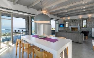 a dining room and living room with a white table and chairs at Asanti Villas in Lévktron