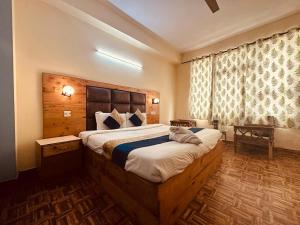 a bedroom with a large bed in a room at Antriksh cottage Manali in Manāli