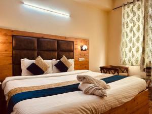 a bedroom with two beds with a stuffed animal on the bed at Antriksh cottage Manali in Manāli