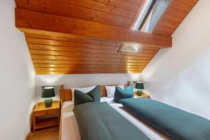 Un dormitorio con dos camas y techo de madera. en Haus Freudig - Tannenblick, en Höchenschwand