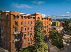 an orange building with trees in front of it at Hotel Imperial - Liburnia in Opatija