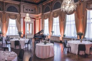 a room with tables and a grand piano in it at Hotel Imperial - Liburnia in Opatija