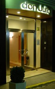 une porte ouverte d'un bâtiment avec un panneau sur celui-ci dans l'établissement Hostal Don Julio, à Sanlúcar la Mayor