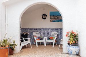 a patio with two chairs and a table and a lamp at Quinta da Avó Bella in Buarcos