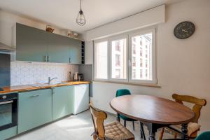 a kitchen with a table and a clock on the wall at Le Petit Schatz in Colmar