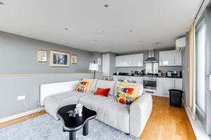 a living room with a couch and a kitchen at Central Bedford Penthouse with Balcony & Parking in Bedford