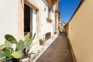 an alley with potted plants on the side of a building at Casa Portosalvo, Modica in Modica