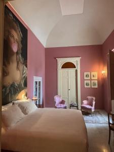 a bedroom with a bed and a painting of a woman at Appartamento Royale Palazzo Villani in Cannole +80 photos