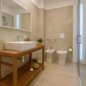 a bathroom with a sink and a toilet at Acquazzurra Rooms in Castellammare del Golfo +15 photos