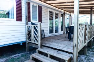 a front porch of a house with a table and chairs at Mobile home confort - Fréjus - camping 4 étoiles - in Fréjus