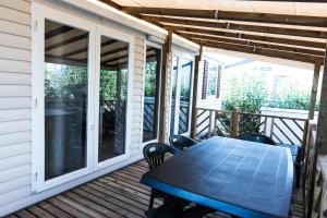 a patio with a table and chairs on a deck at Mobile home confort - Fréjus - camping 4 étoiles - in Fréjus