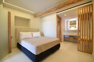 Un dormitorio con una cama y un baño. en Potis Suites, en Almirón