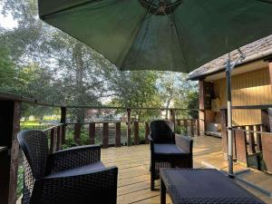a patio with two chairs and an umbrella on a deck at Zsófia faház in Vásárosnamény