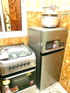a kitchen with a stove and a pot on top of it at Porche apart mimboman Yde in Kofa +30 photos