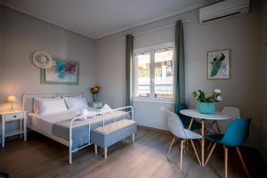 a bedroom with a bed and a table and chairs at Peacock's Apartments in Piraeus