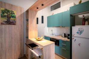 a kitchen with green cabinets and a white refrigerator at Peacock's Apartments in Piraeus