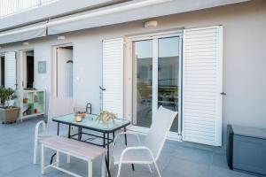 a patio with a table and chairs on a patio at Peacock's Apartments in Piraeus
