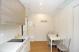 een keuken met witte werkbladen en een tafel en stoelen bij Via Torino Apartment 3 in Milaan