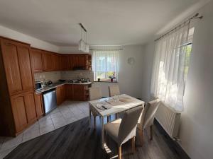 a kitchen and dining room with a table and chairs at Samaria Apartments in Šamorín