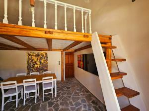 a dining room with a table and some stairs at BROWN ON GREEN a stone house with amazing view in Drapaniás