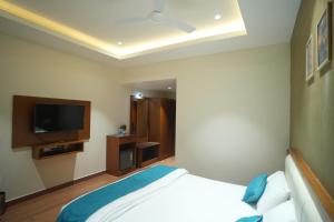 a bedroom with a bed and a flat screen tv at Hotel Avasa in Tenāli
