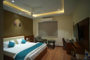 a hotel room with a bed and a tv at Hotel Avasa in Tenāli