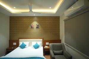 a hotel room with a bed and a chair at Hotel Avasa in Tenāli +35 photos