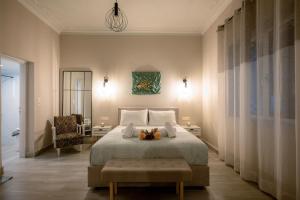 a bedroom with a large bed and a chair at Peacock's Apartments in Piraeus