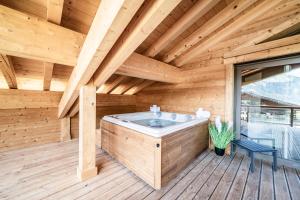 シャテルにあるApartment Nightfall Châtel - by EMERALD STAYの木製のデッキにホットタブがある木造の部屋
