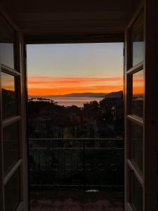 a view of a sunset from a window at Sea-view apartment with balcony & free private parking, Camogli in Camogli
