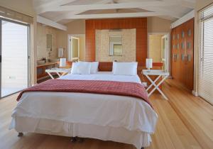 a large bedroom with a large bed and a bathroom at Dune Rose Yzerfontein Villa in Yzerfontein +54 photos