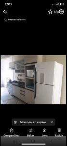 a picture of a kitchen with a white refrigerator at Chalé Ricmarques in Esteio