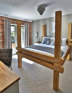 a bedroom with a large wooden bed in a room at Cock O' Barton in Coddington