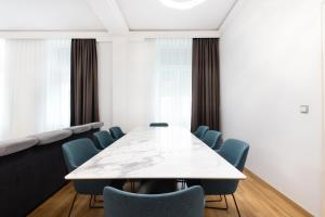 einen Konferenzraum mit einem weißen Tisch und blauen Stühlen in der Unterkunft Lé David City Apartments 1020 in Wien