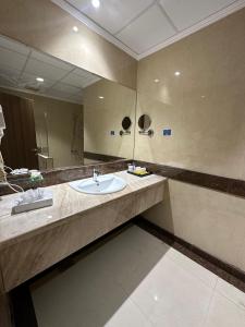 a bathroom with a sink and a large mirror at شقق جوين للوحدات السكنية المفروشة- اقتصادي in Jeddah